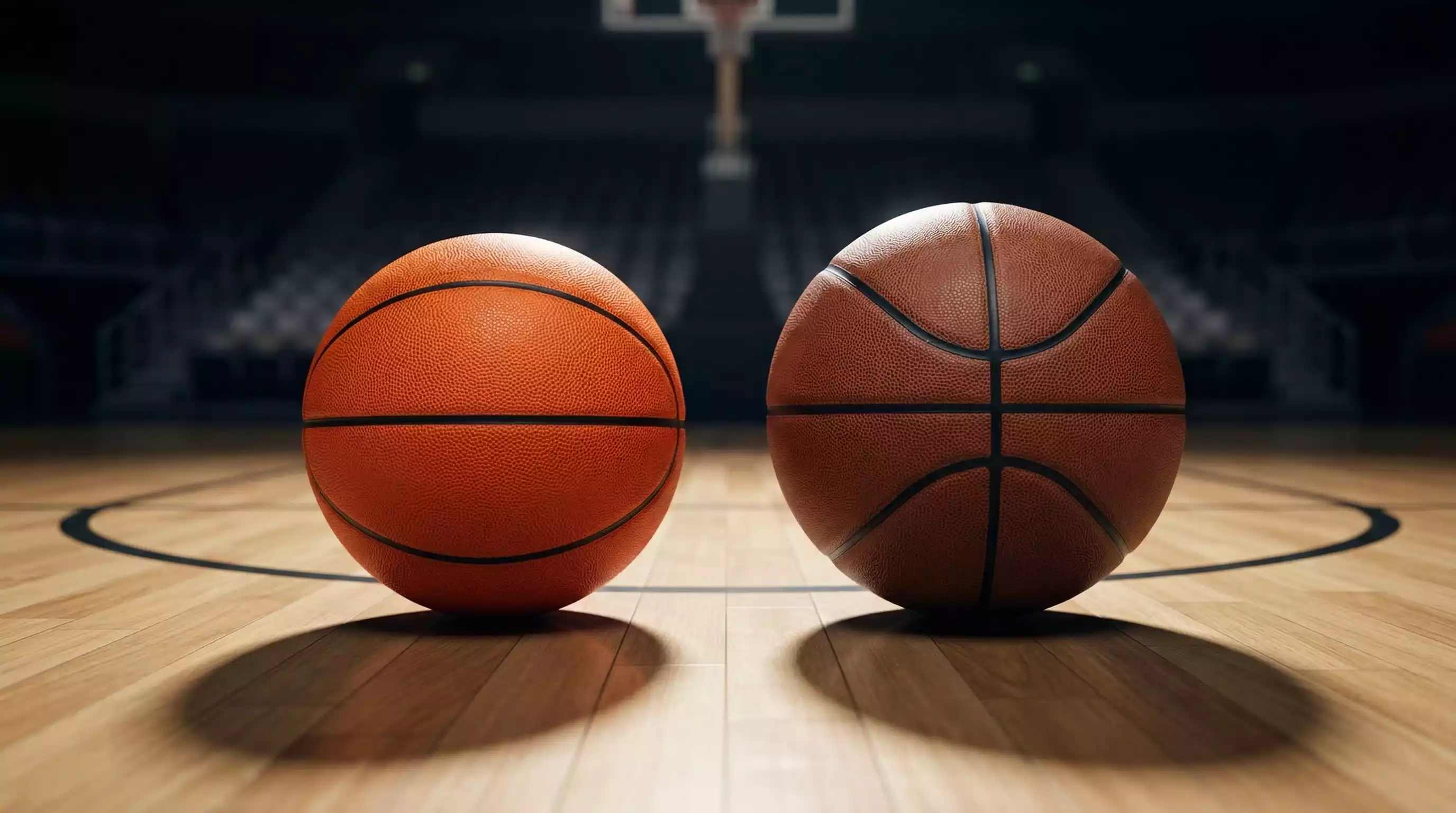 Dos balones de baloncesto FIBA y NBA lado a lado sobre una pista de parqué
